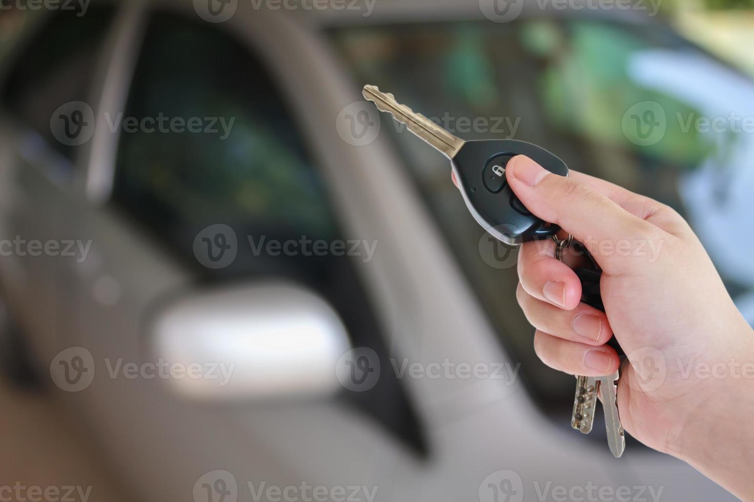 vrouwenhanddrukken op de autoalarmsystemen met afstandsbediening foto