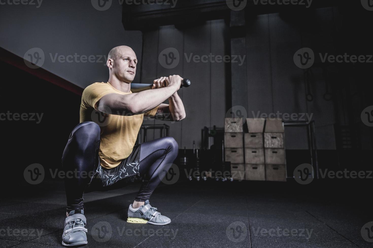 atleet doet oefening met clubbel in de sportschool. foto