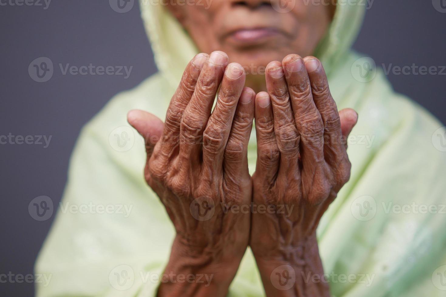 close up van senior vrouwen hand bidden in ramadan foto
