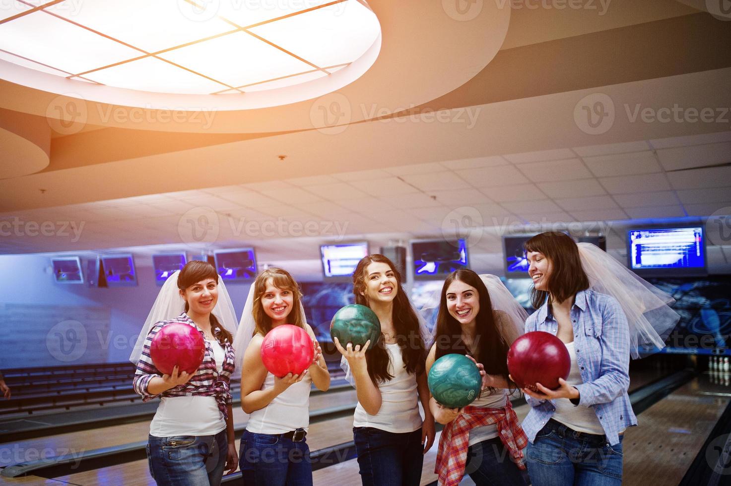 groep van zes meisjes met bowlingballen op vrijgezellenfeest op bowlingclub. foto