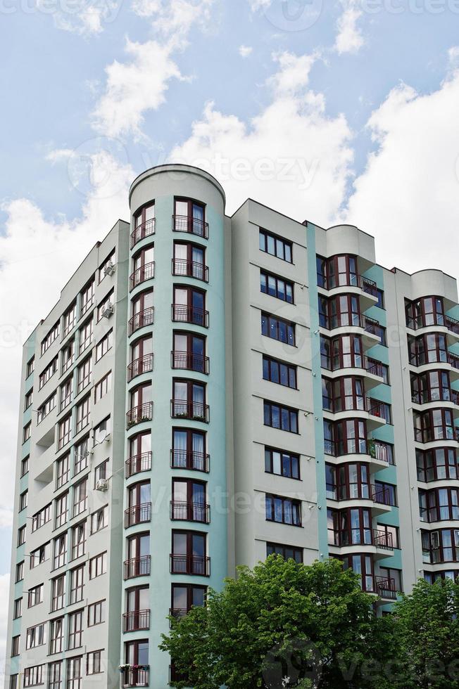 balkon van nieuwe moderne turquoise woongebouw met meerdere verdiepingen in woonwijk op zonnige blauwe hemel. foto