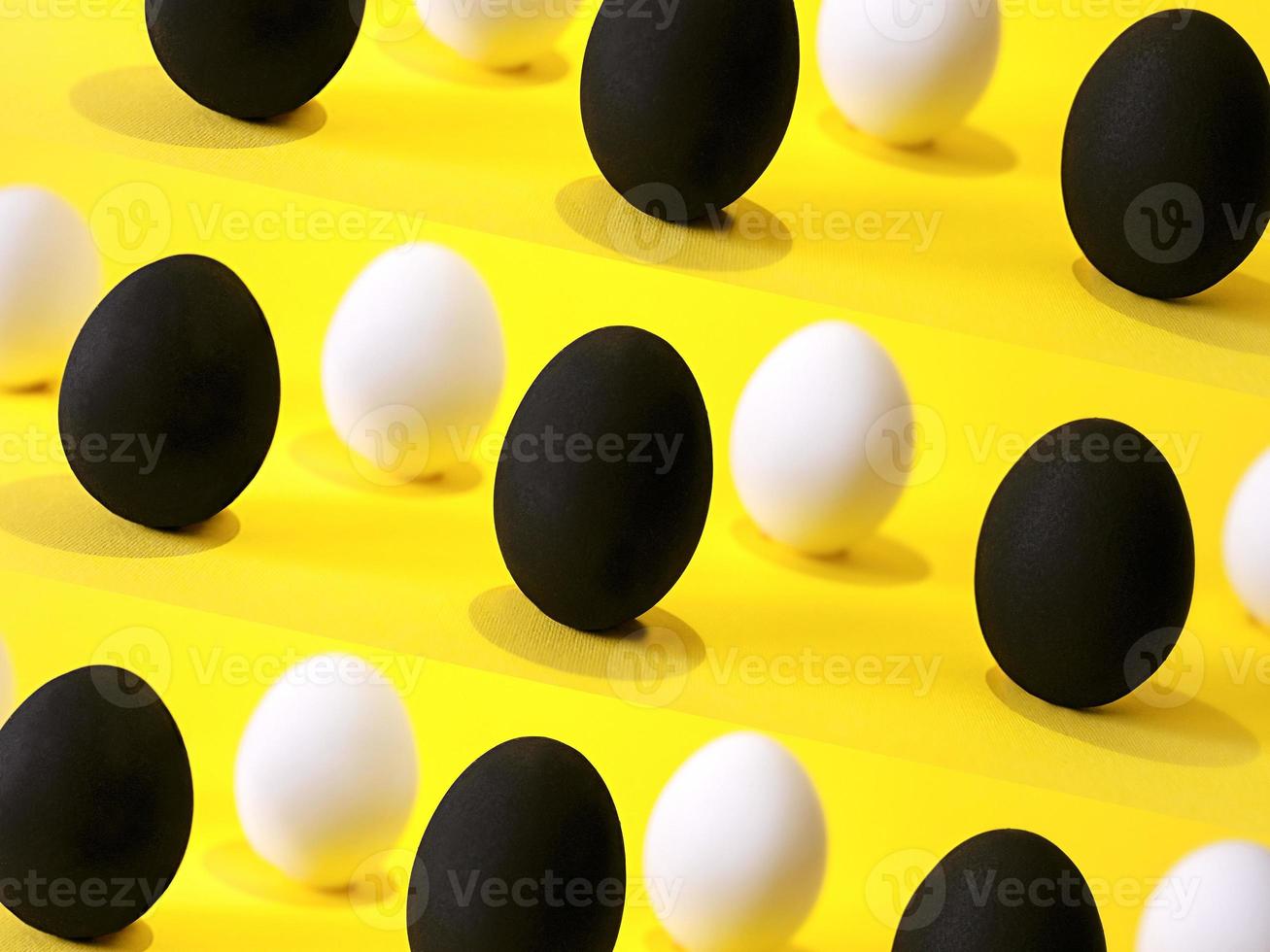zwarte en witte eieren op de gele achtergrond. foto