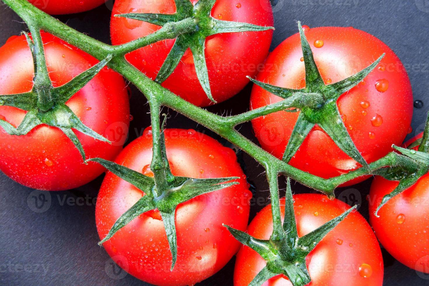 close-up van enkele rijpe tomaten aan de tros foto