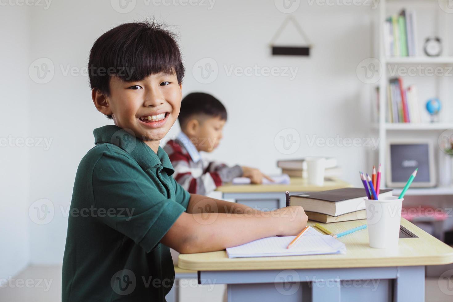 lachende Aziatische student die naar de camera kijkt in een klas foto