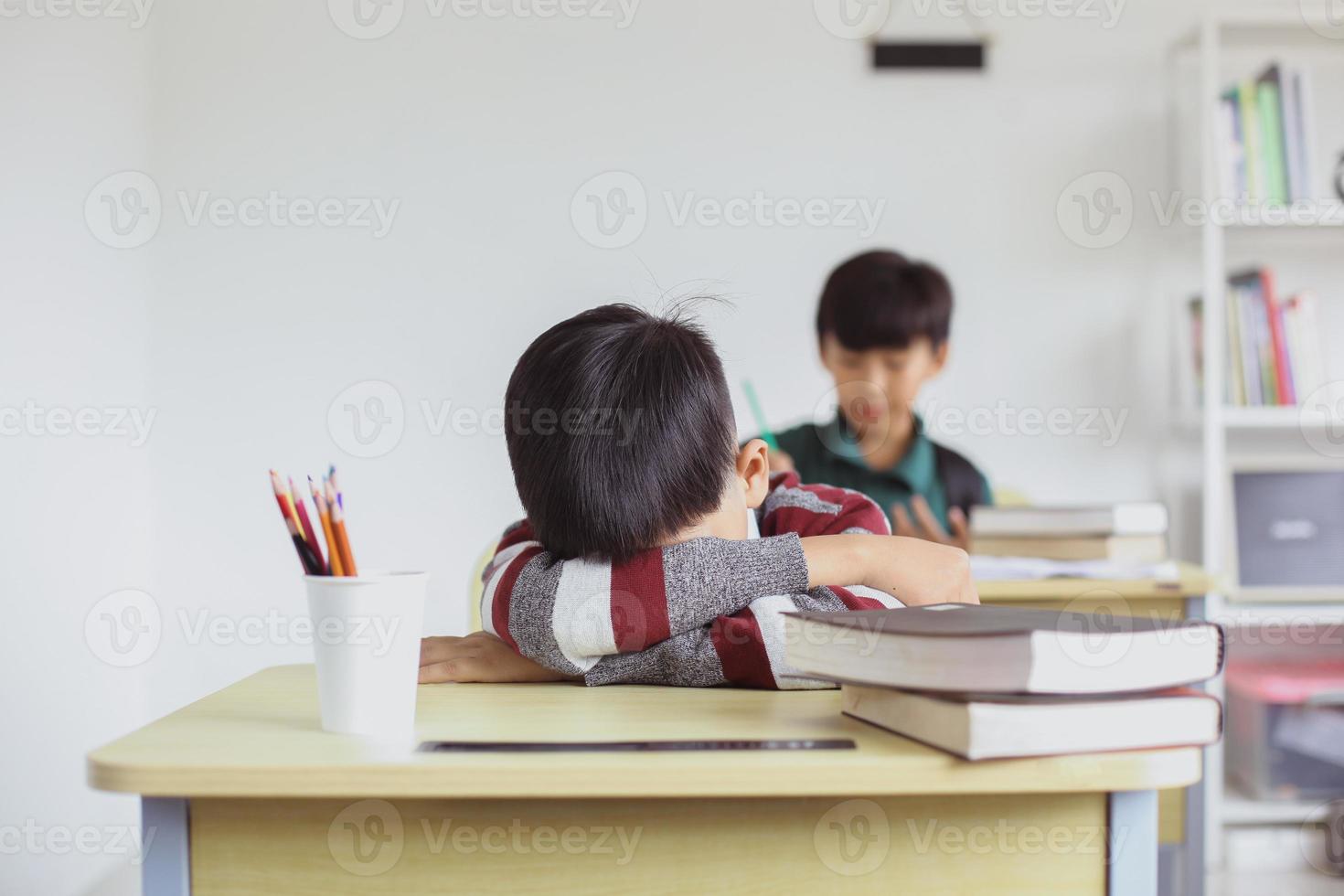 een schooljongen valt tijdens de les in slaap foto