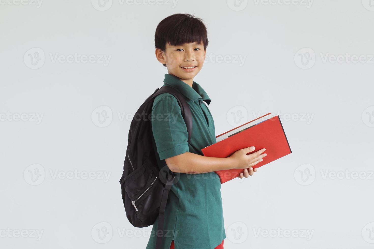 glimlachende Aziatische student die naar de camera kijkt terwijl hij een boek vasthoudt foto