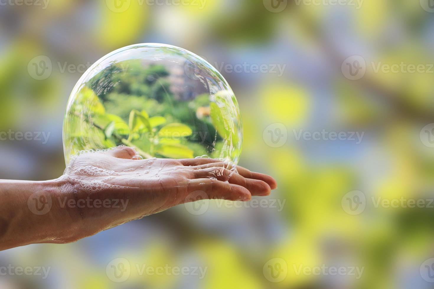 hand van man houdt zeepbel zeepsop op palm geïsoleerd op onscherpe achtergrond met uitknippad. foto