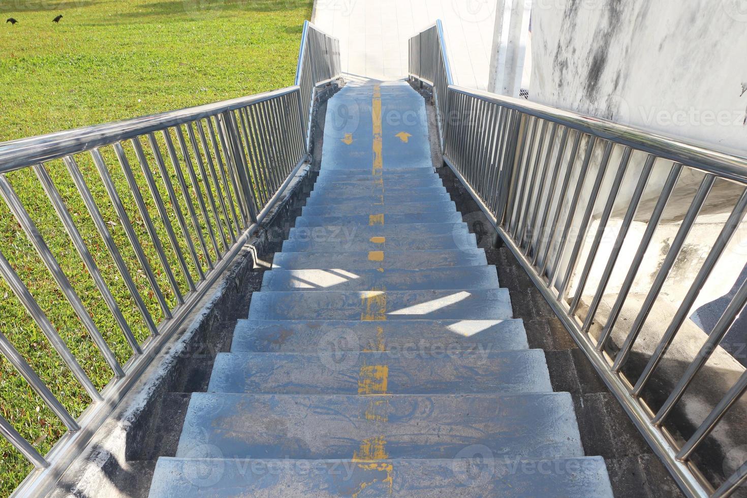 betonnen trappen van een loopbrug met roestvrijstalen leuningen. foto