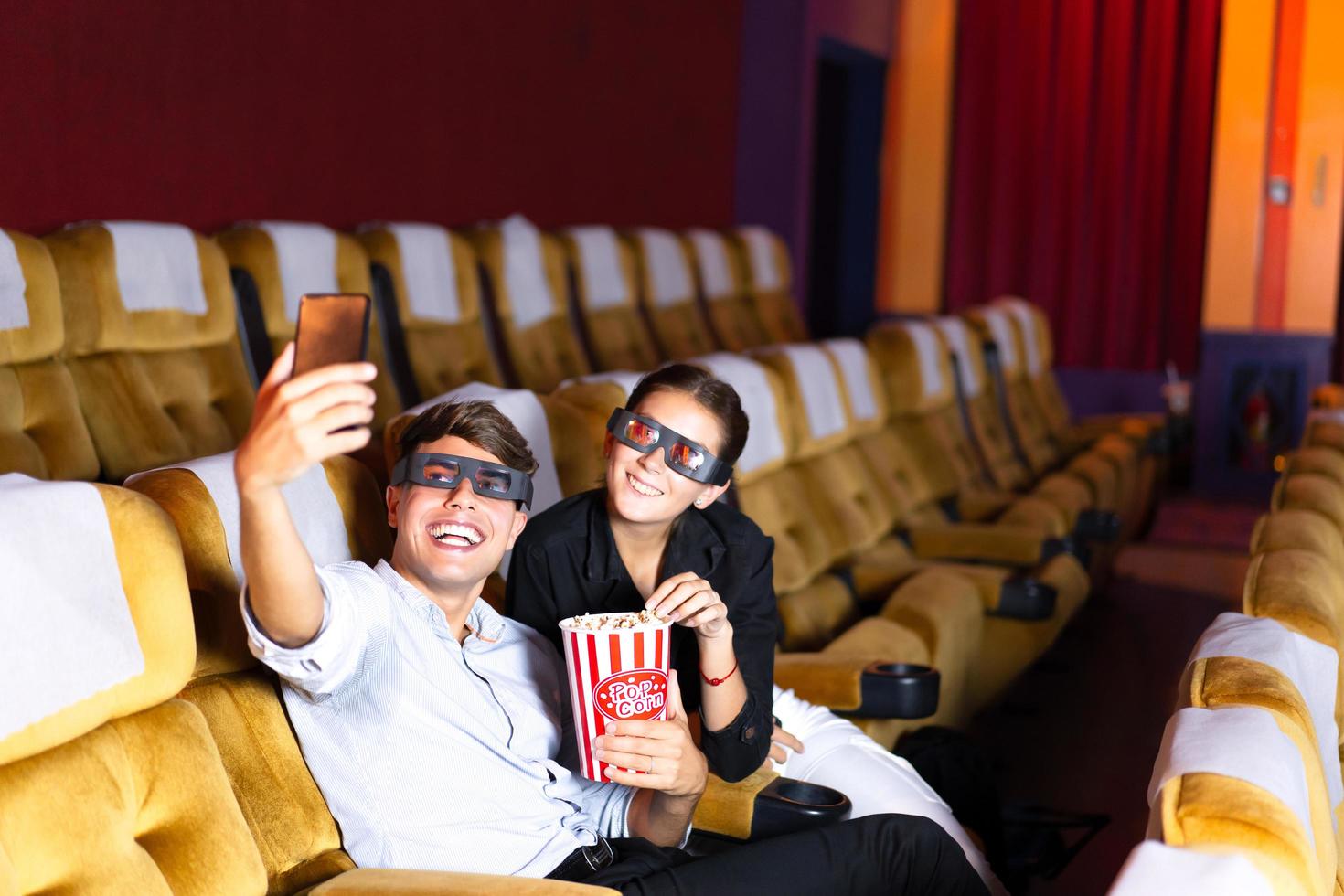 blanke man en vrouw nemen een selfie in de bioscoop. foto
