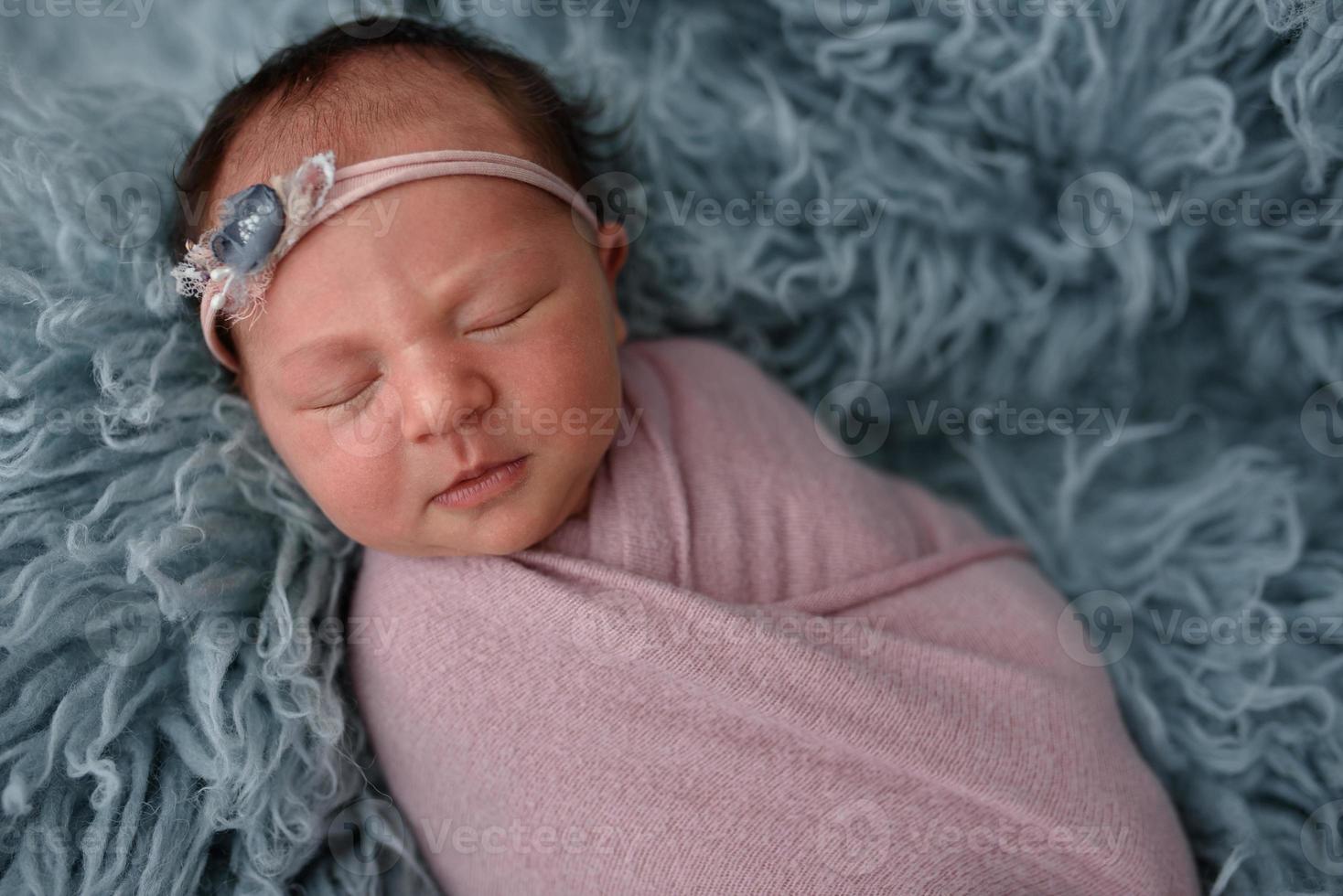 portret van een slapende pasgeboren baby in blauw bont foto