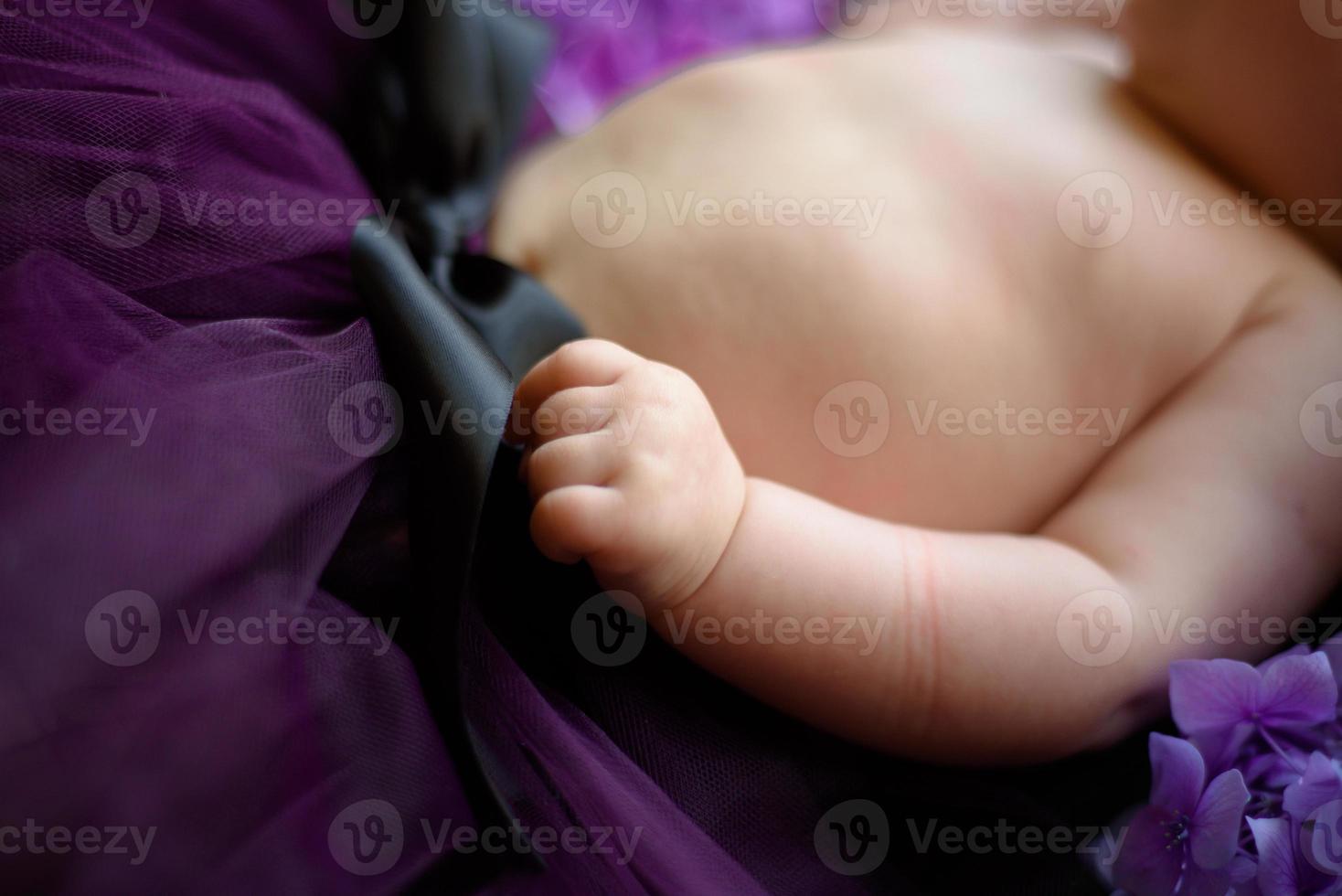 portret van een schattig klein meisje. baby ligt in de kleuren van paarse hortensia foto