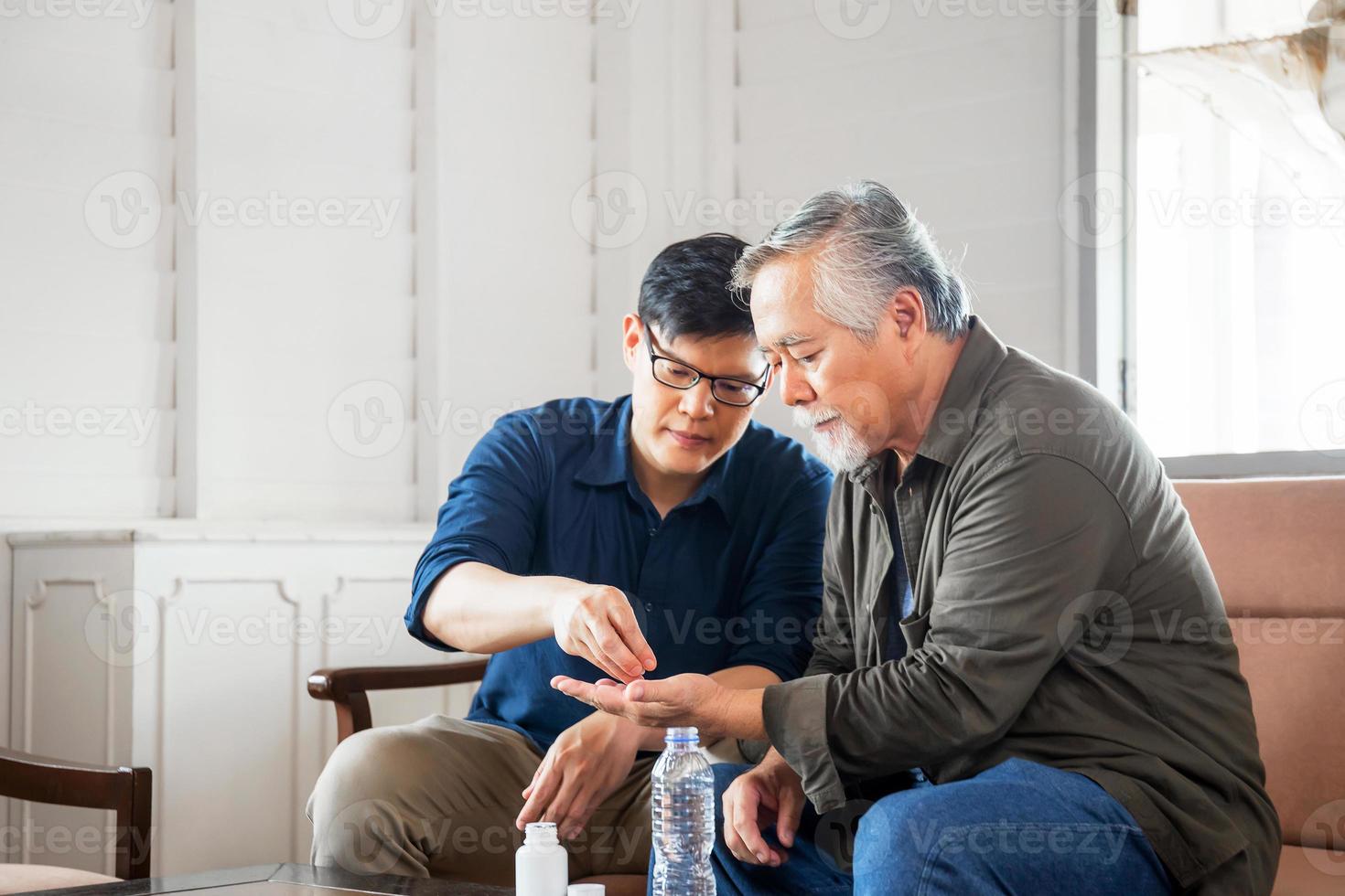 zoon van middelbare leeftijd zorgt voor zieke senior vader, geluk Aziatische familieconcepten foto