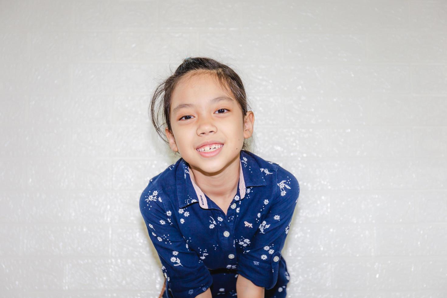 portret van een gelukkig klein meisje dat lacht en naar de camera kijkt met een onscherpe achtergrond foto