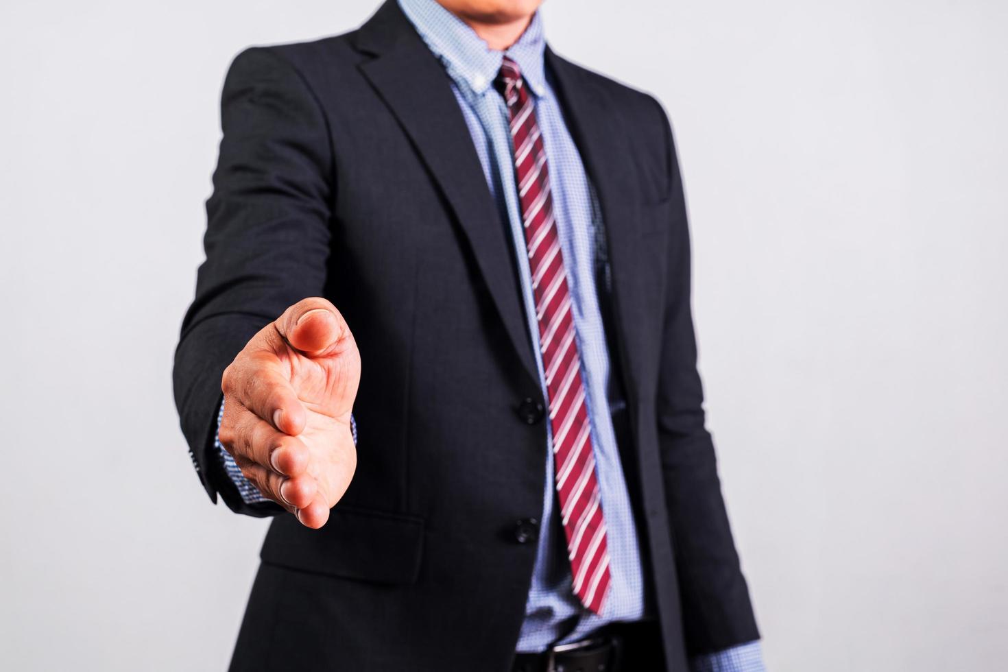 een zakenman die een pak draagt, steekt zijn rechterhand uit om handen te schudden. foto