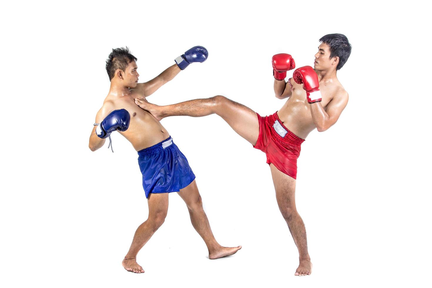 Twee Thaise boksers die traditionele krijgskunst uitoefenen, geïsoleerd op een witte achtergrond foto