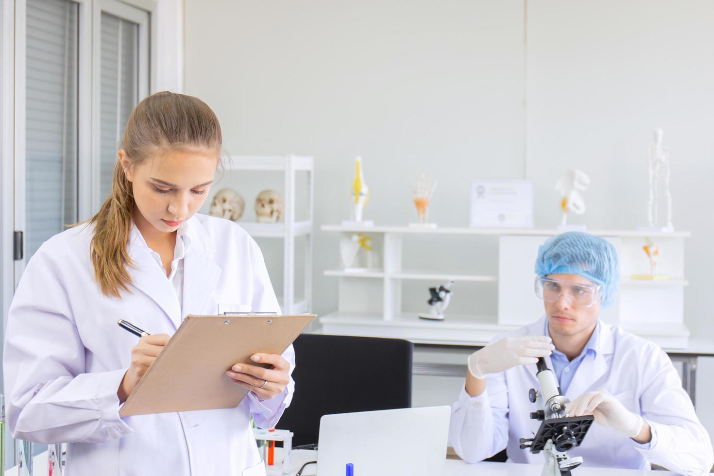 wetenschappers, jonge mannen en vrouwen in het laboratorium foto