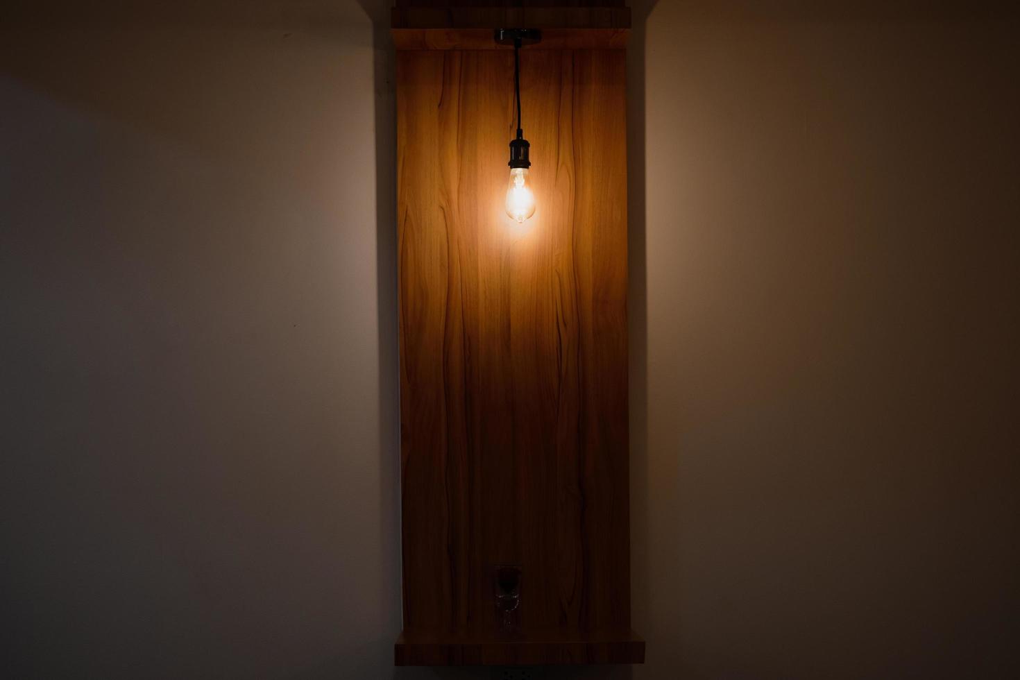 een aan het plafond hangende gloeilamp verlicht een ietwat donkere kamer en geeft het een warm gevoel. ideeën voor kamerdecoratie. foto