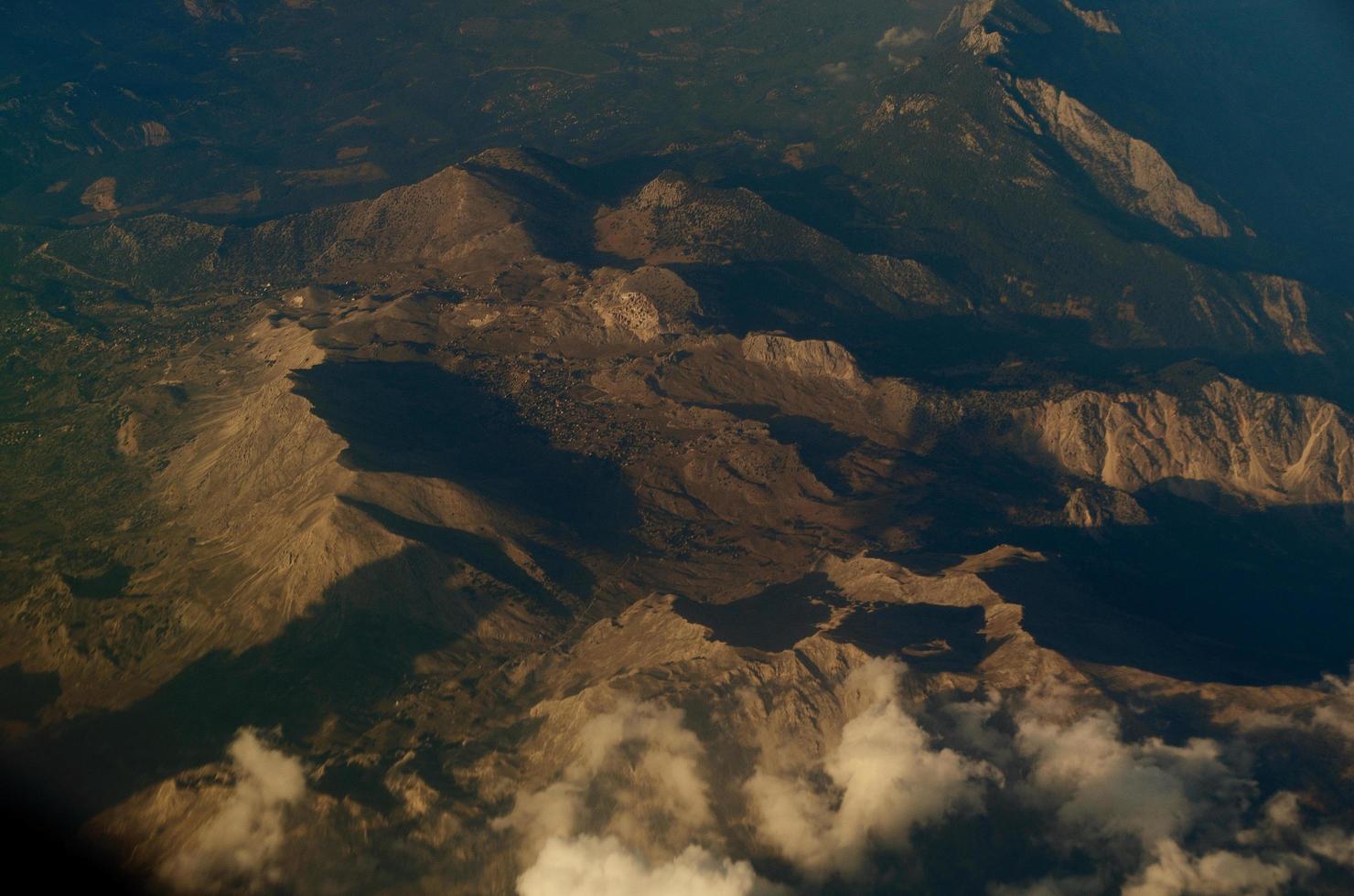 bergen met wolken vanuit vliegtuig foto