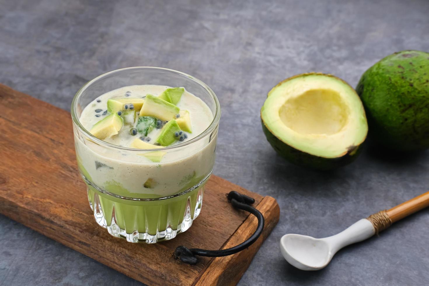 avocado melk kaas dessert is gemaakt van avocado, gelei, kaas, basilicum zaden, gezoete gecondenseerde melk en verdampte melk. geserveerd in een glas. ruimte voor tekst foto