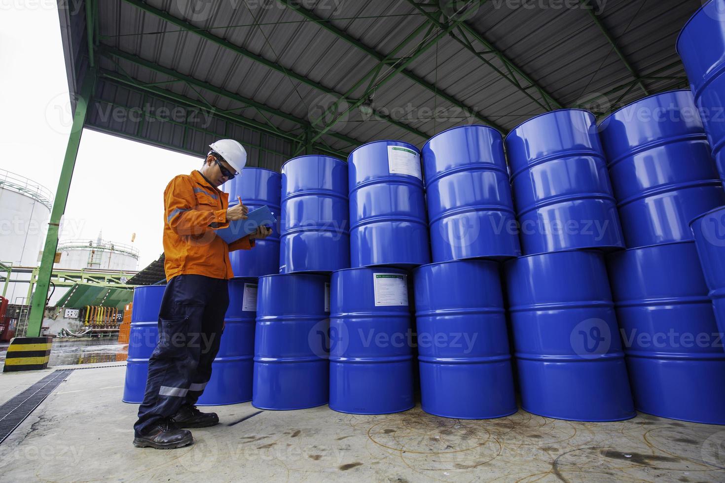 mannelijke werknemer inspectie record drum olie voorraad vaten blauw horizontaal of chemisch foto