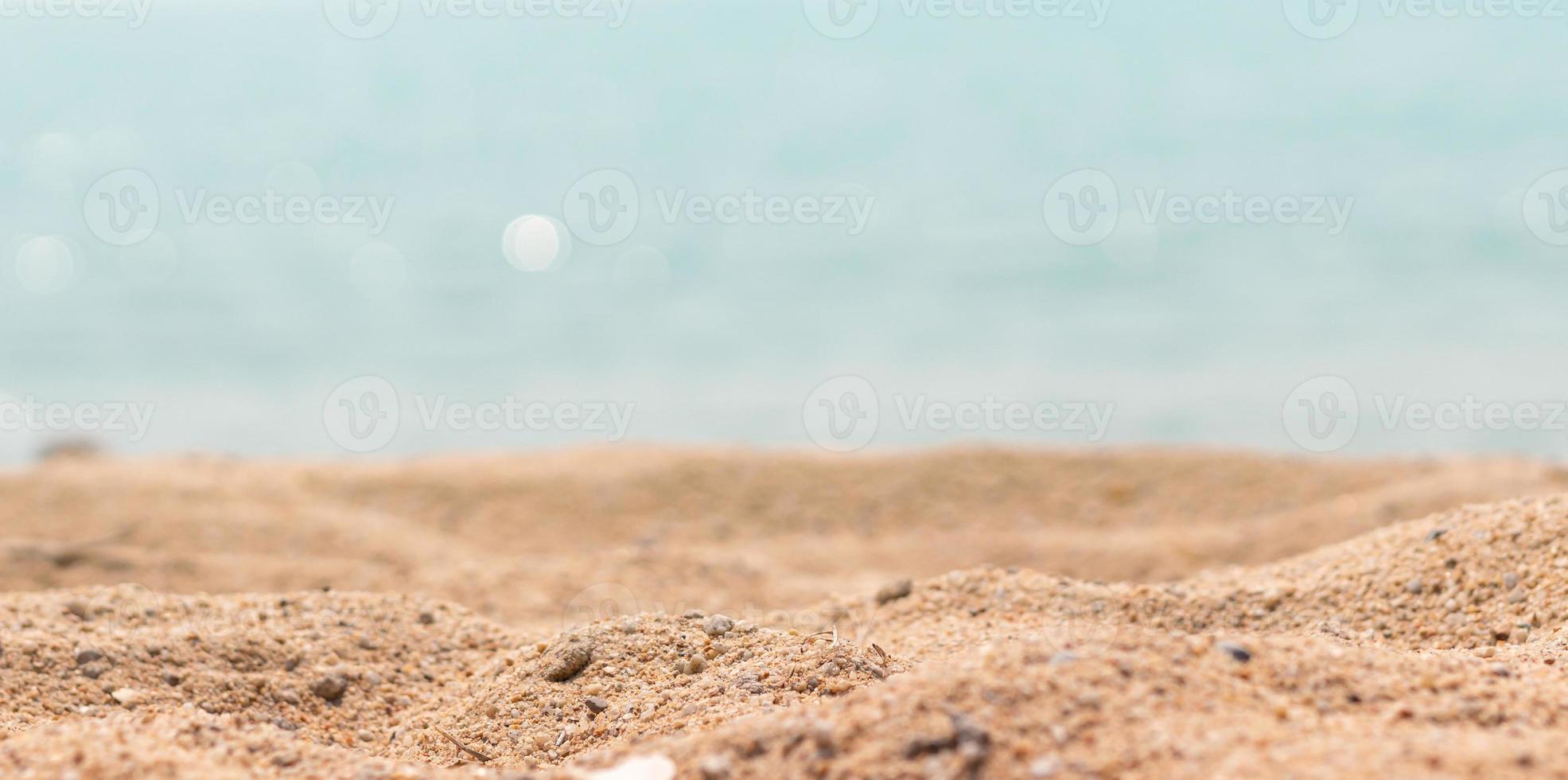 close-up oppervlak van zand op het strand en vervaag de voorgrond en vervaag bokeh zee achtergrond foto