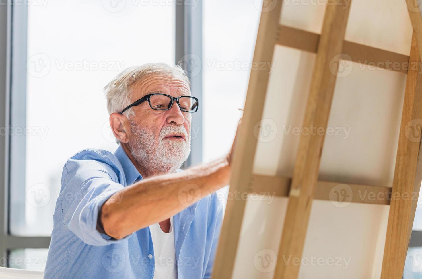 senior man schilderen op canvas thuis, oudere man schilderen op een canvas, gelukkige pensionering concepten foto