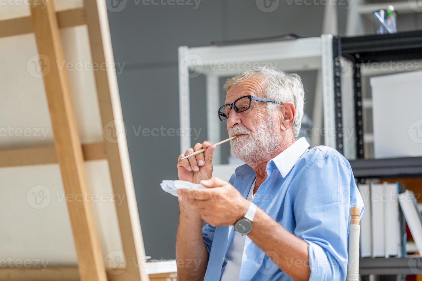 senior man schilderen op canvas thuis, oudere man mannelijke kunstenaar tekenen in kunststudio, gelukkige pensionering concepten foto
