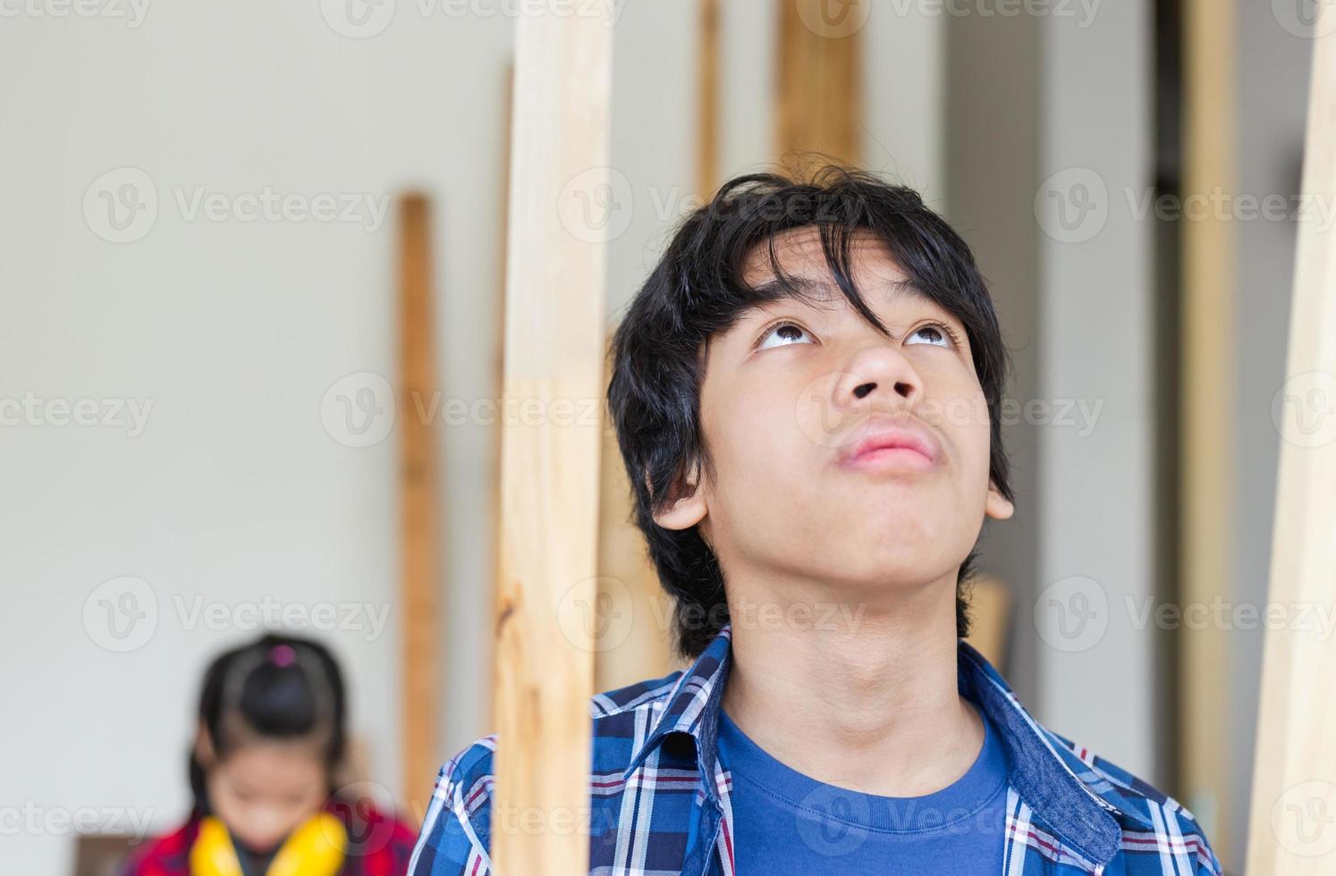 kinderen leren houtbewerking in de ambachtswerkplaats, tienerjongen met zijn zusje die samen een werkplaats bouwt in een timmerwerkplaats foto