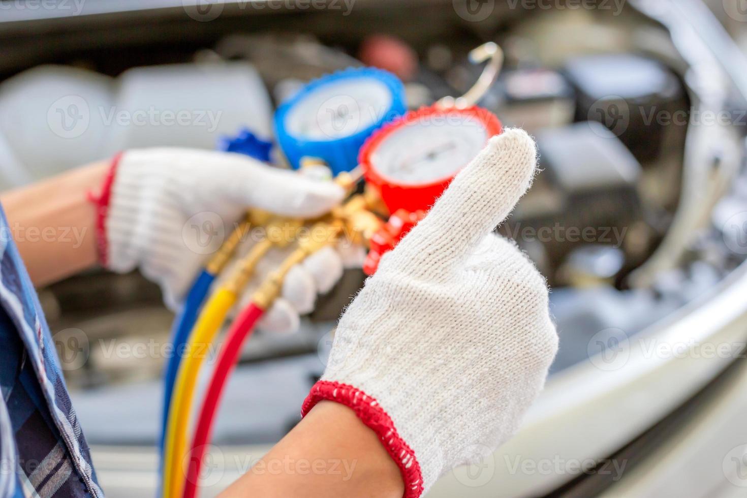 airconditioning reparatie, reparateur geeft duimen omhoog en houdt monitortool vast om auto-airconditionersysteem te controleren en vast te stellen, technicus controleert auto-airconditioningsysteem koelmiddel bijvullen foto