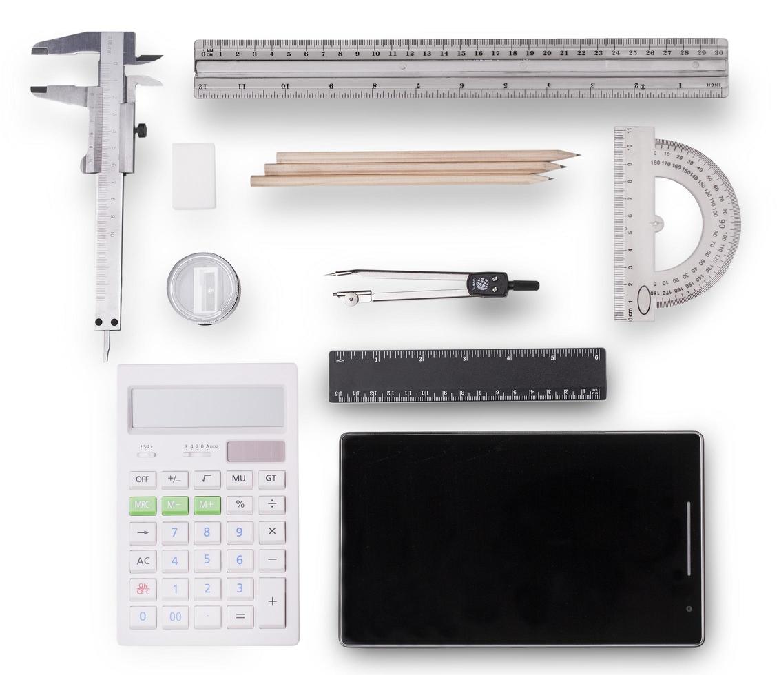 tablet, rekenmachine, liniaal, potlood en kompas op witte achtergrond. foto