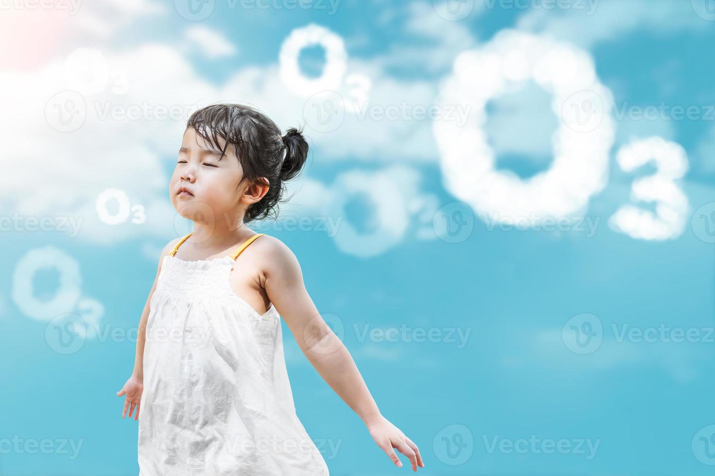 Aziatisch meisje in witte jurk glimlachend en sta op en adem op o3-tekst op blauwe hemelachtergrond voor wereldozondag foto