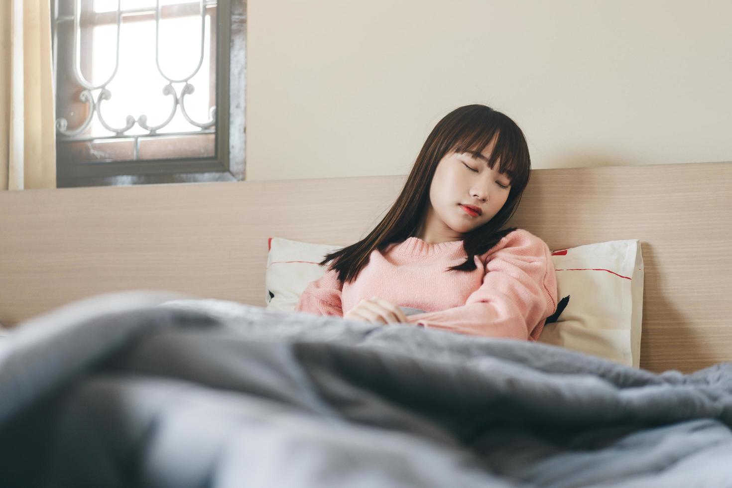 jonge Aziatische schattige tienervrouw slaapt 's ochtends in de slaapkamer foto