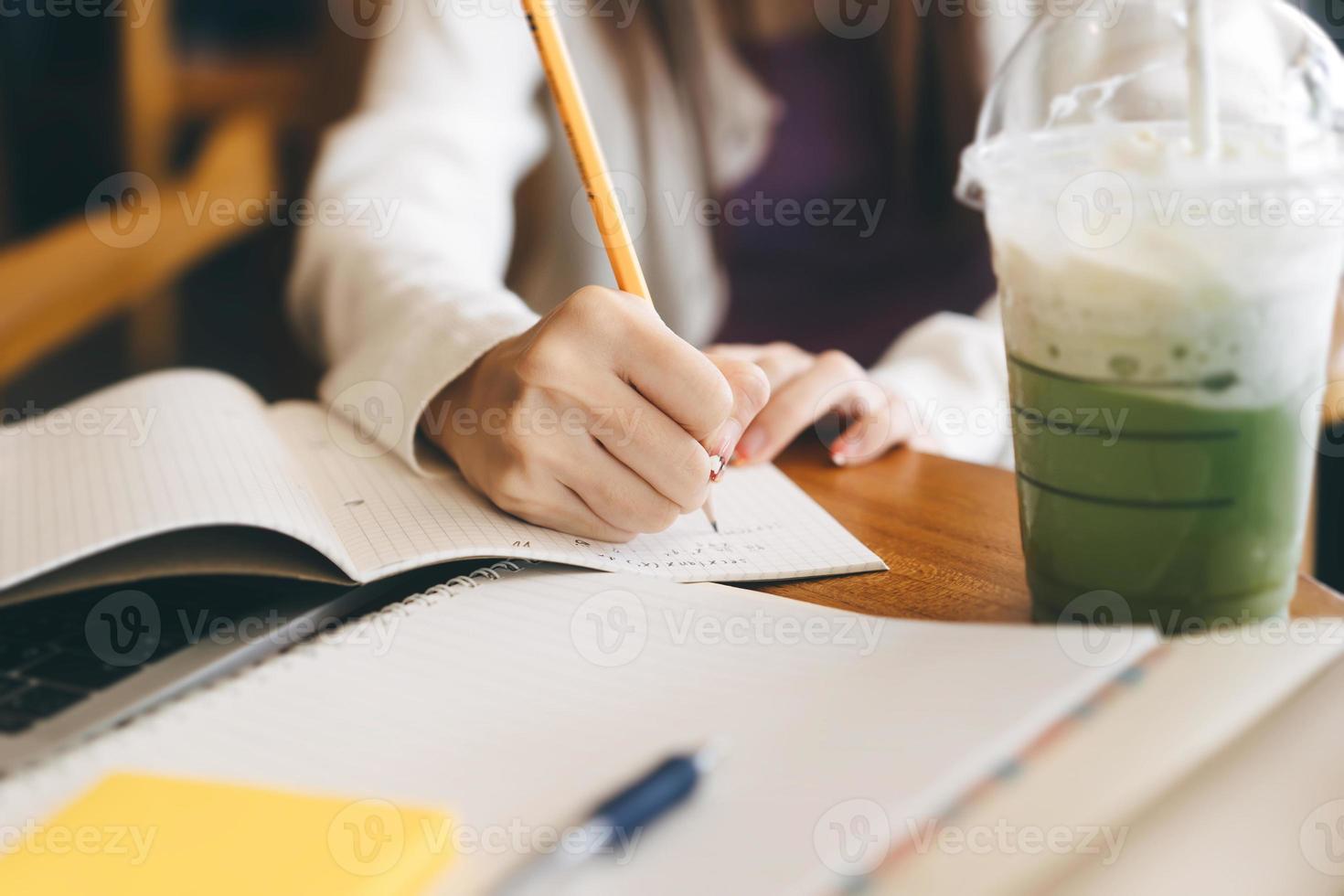 close-up vrouwen hand schrijven notitie wiskunde studie in café. foto