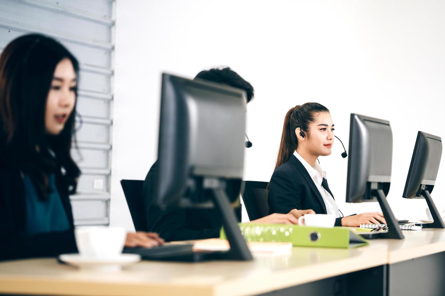 jonge zakelijke medewerkers aziatische vrouw die met hoofdtelefoon en computer werkt voor ondersteuning. foto