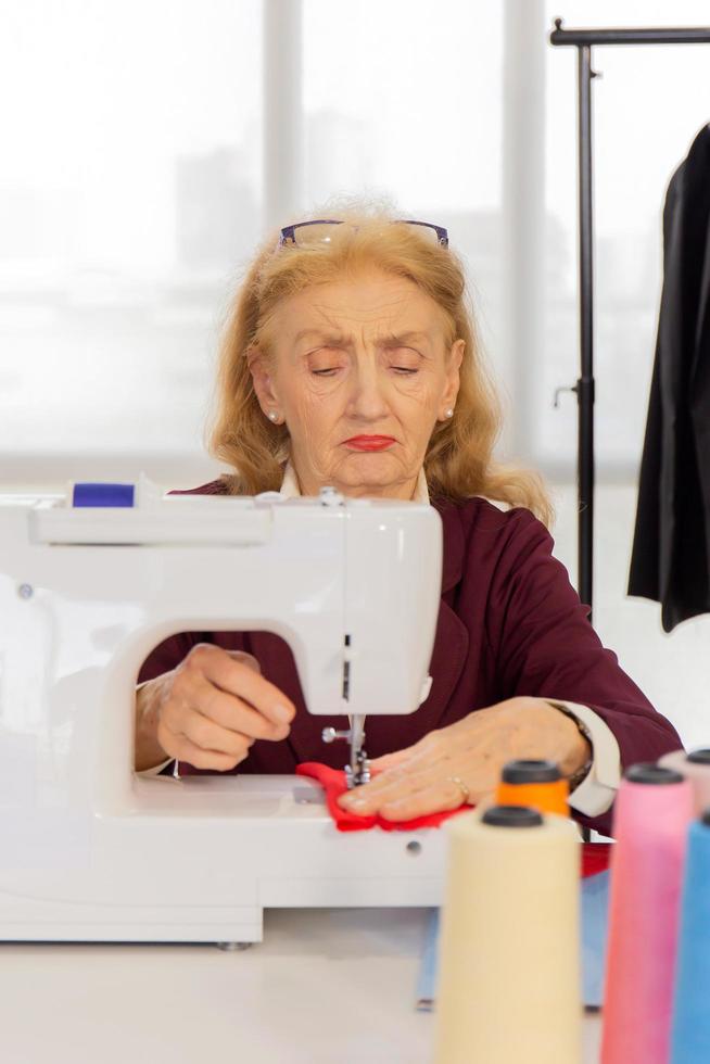 professionele vrouwelijke ontwerpers naaien met kleine naaimachines op tafel. foto
