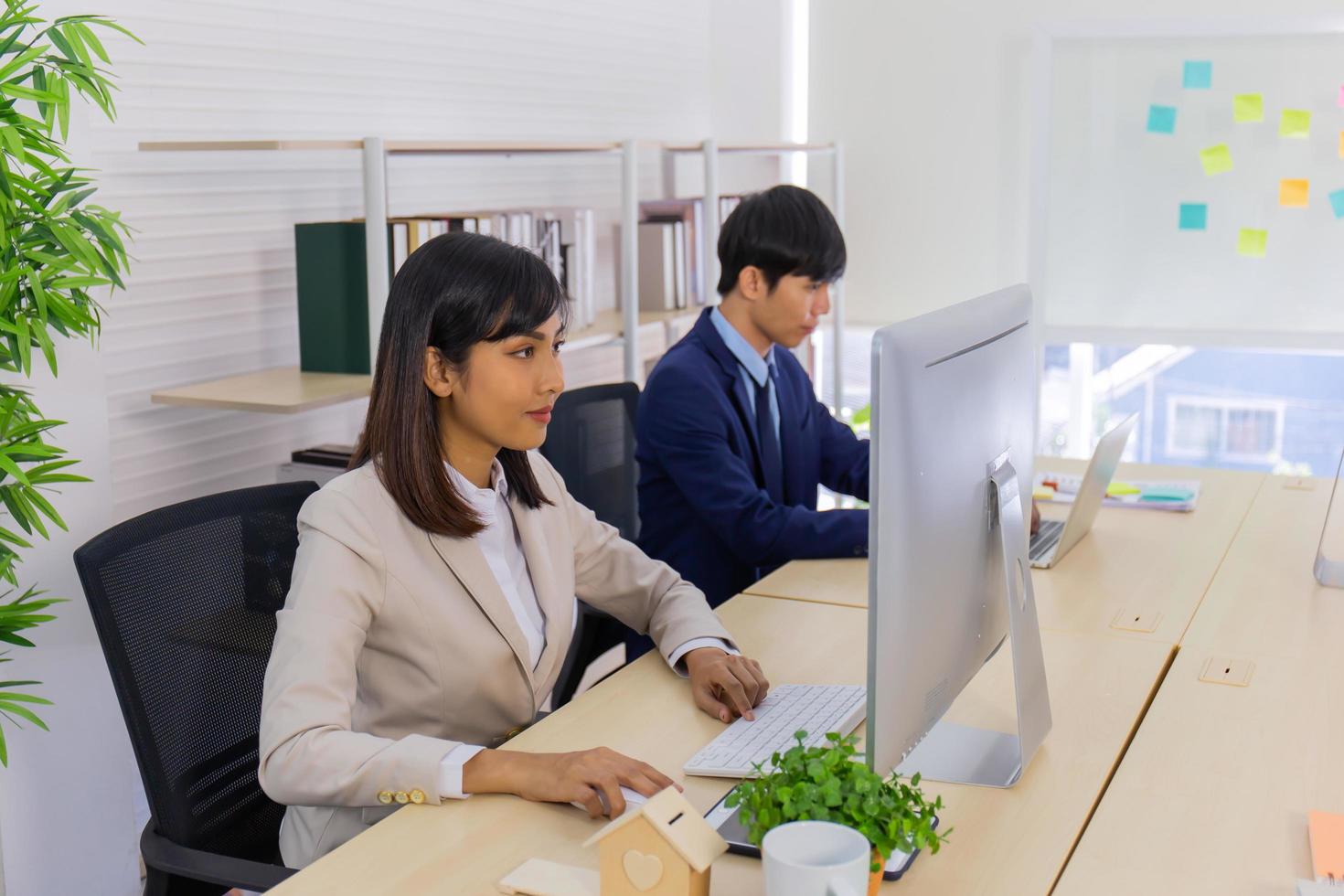 twee mannelijke zakenlieden en zakenvrouwen zitten ijverig op kantoor. foto
