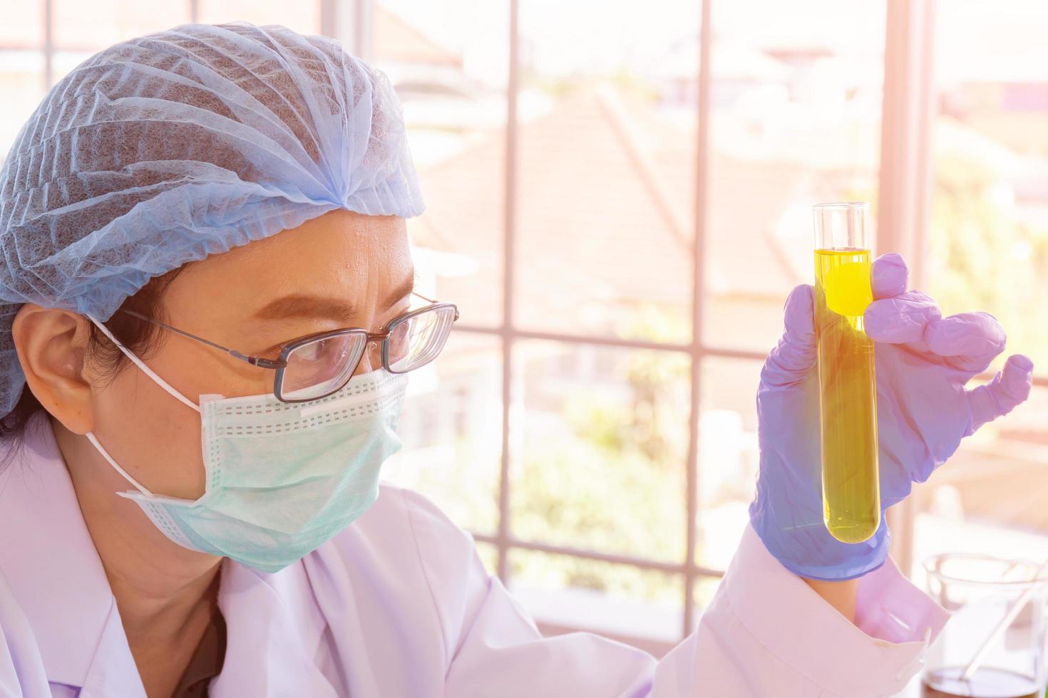 een Aziatische vrouwelijke wetenschapper onderzoekt een chemische formule in een laboratorium. foto