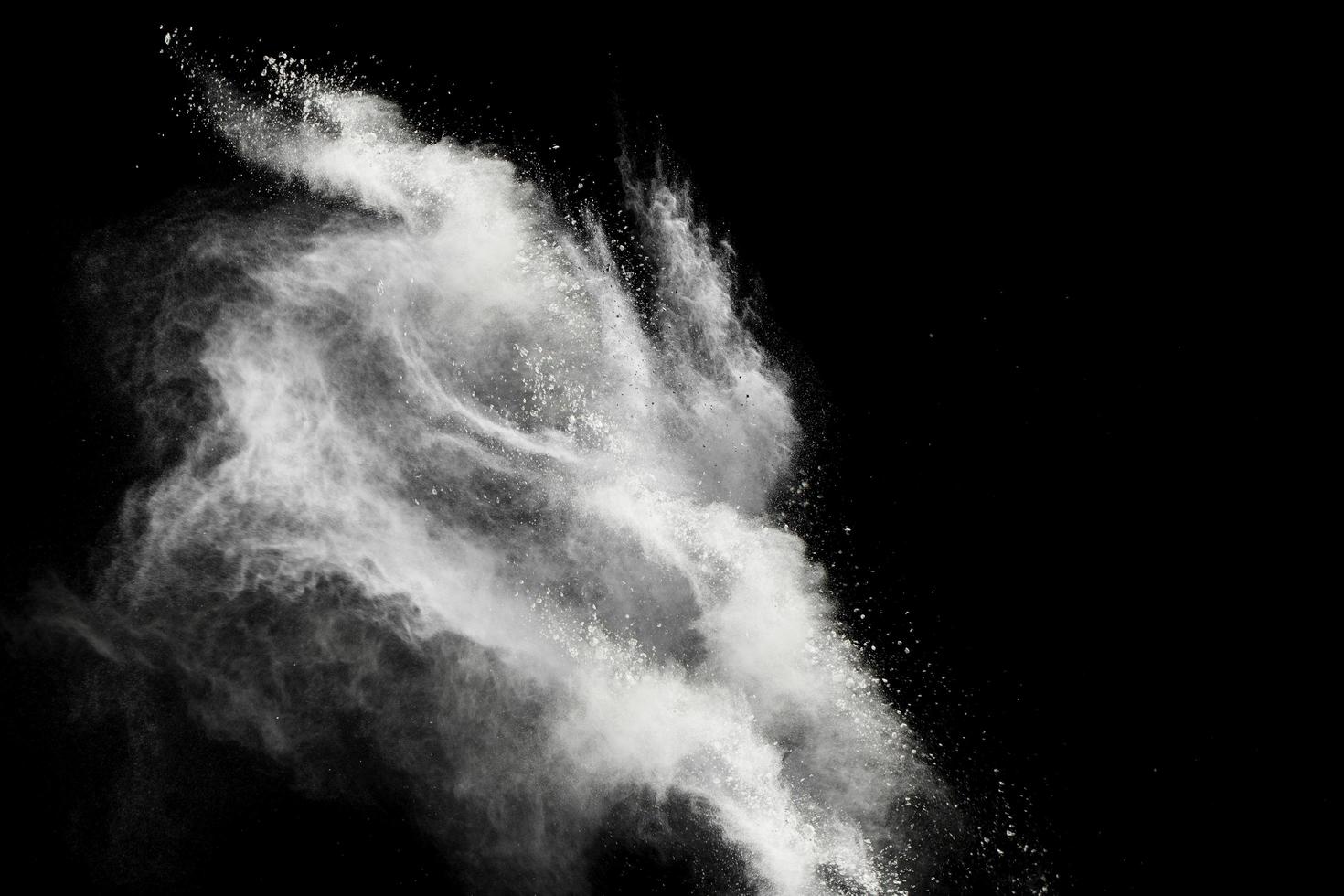 bevriezen beweging van explosies van wit poeder geïsoleerd op zwarte achtergrond foto