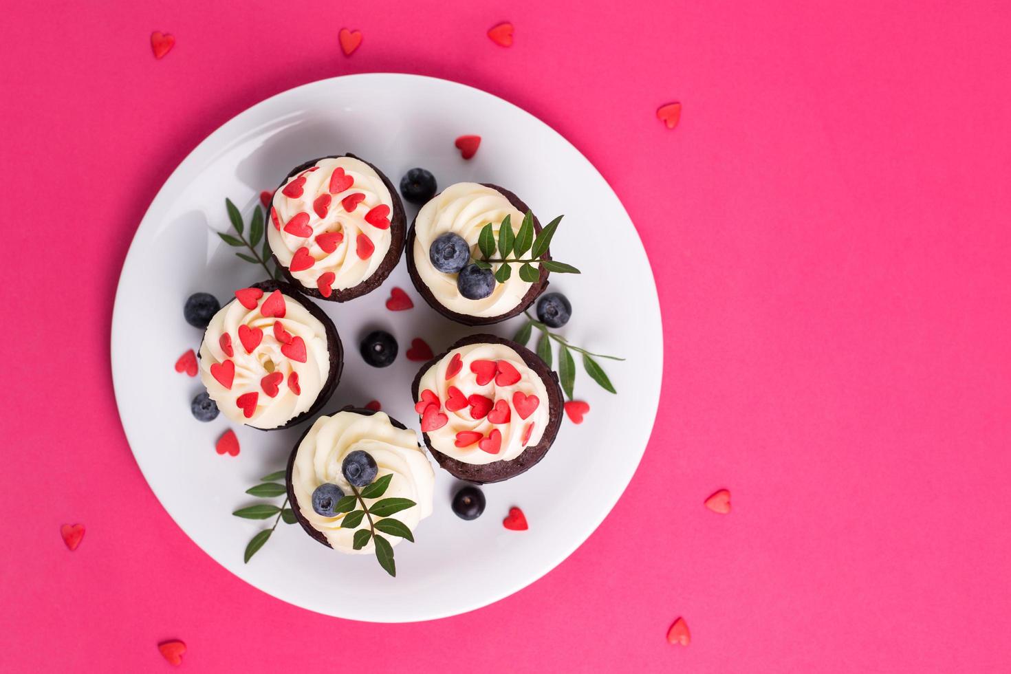 roodfluwelen cupcakes voor Valentijnsdag in een felroze setting foto