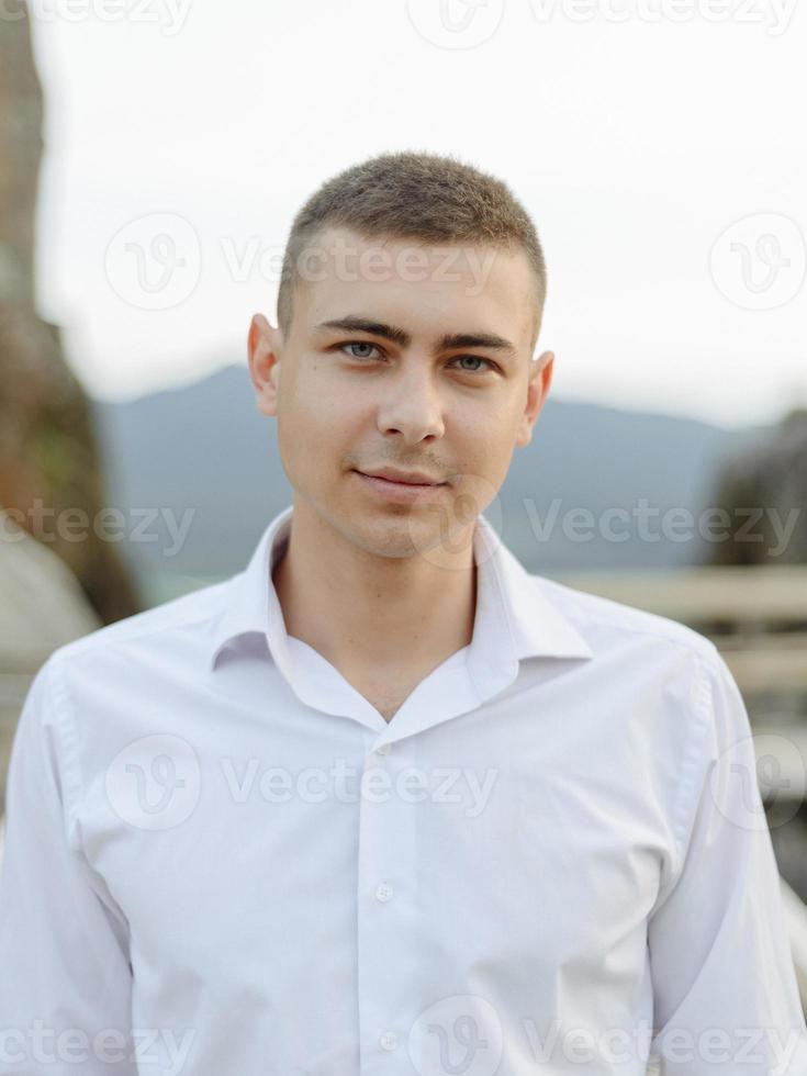 portret van een jonge bruidegom geschoten in de bergen foto