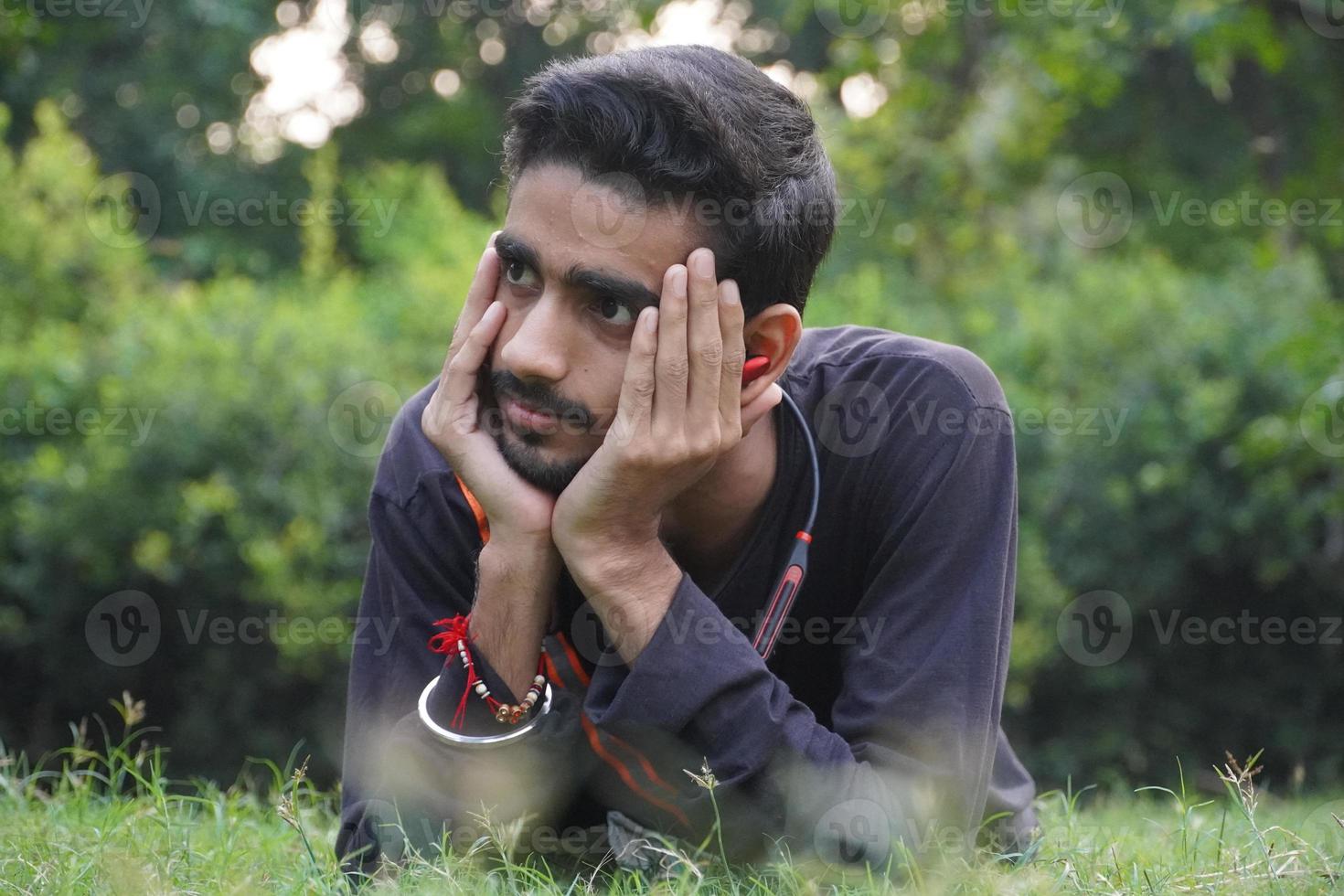 portret van Indiase jonge man dacht in park foto