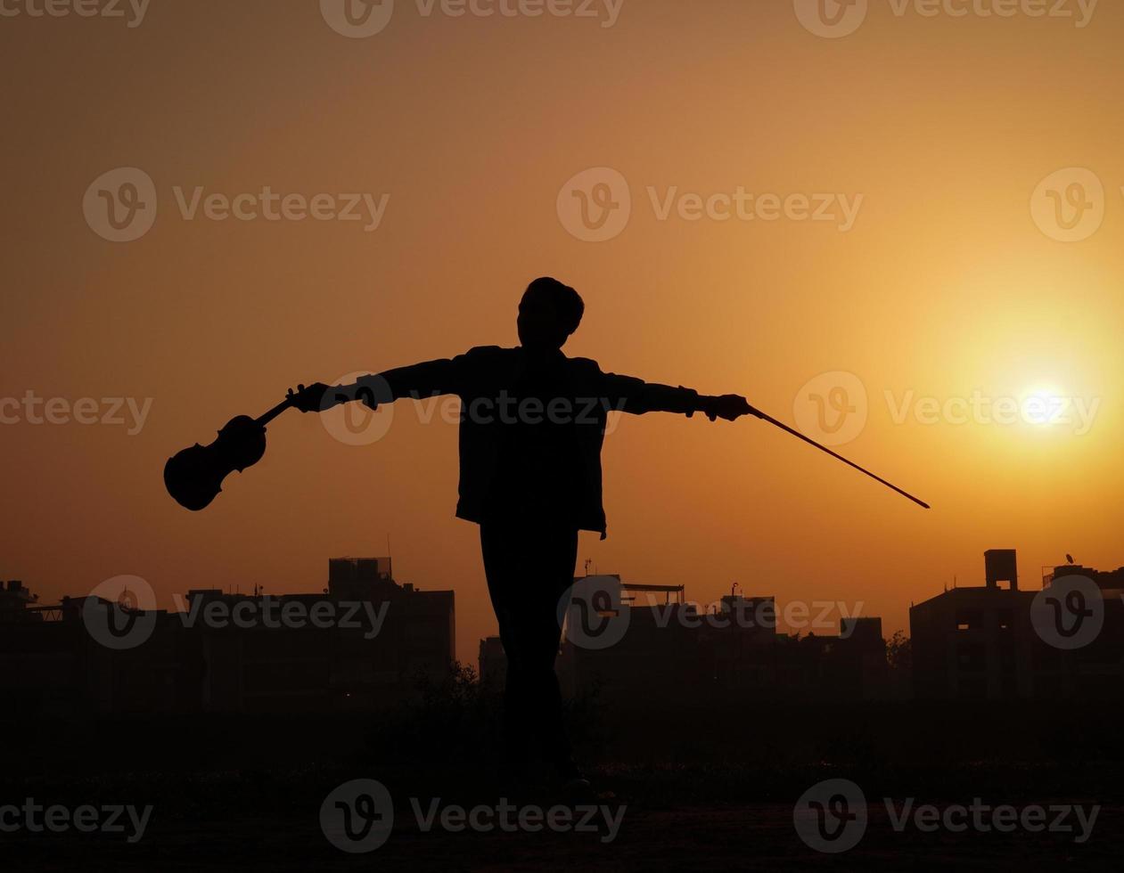 muzikant die viool speelt. muziek en muzikaal toonconcept. silhouetafbeeldingen van man muzikant foto