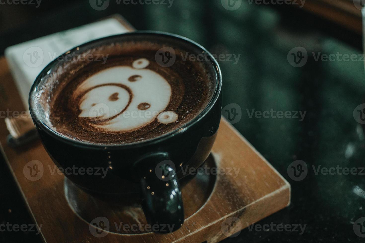 een kopje koffie latte art op houten tafel - afbeelding foto