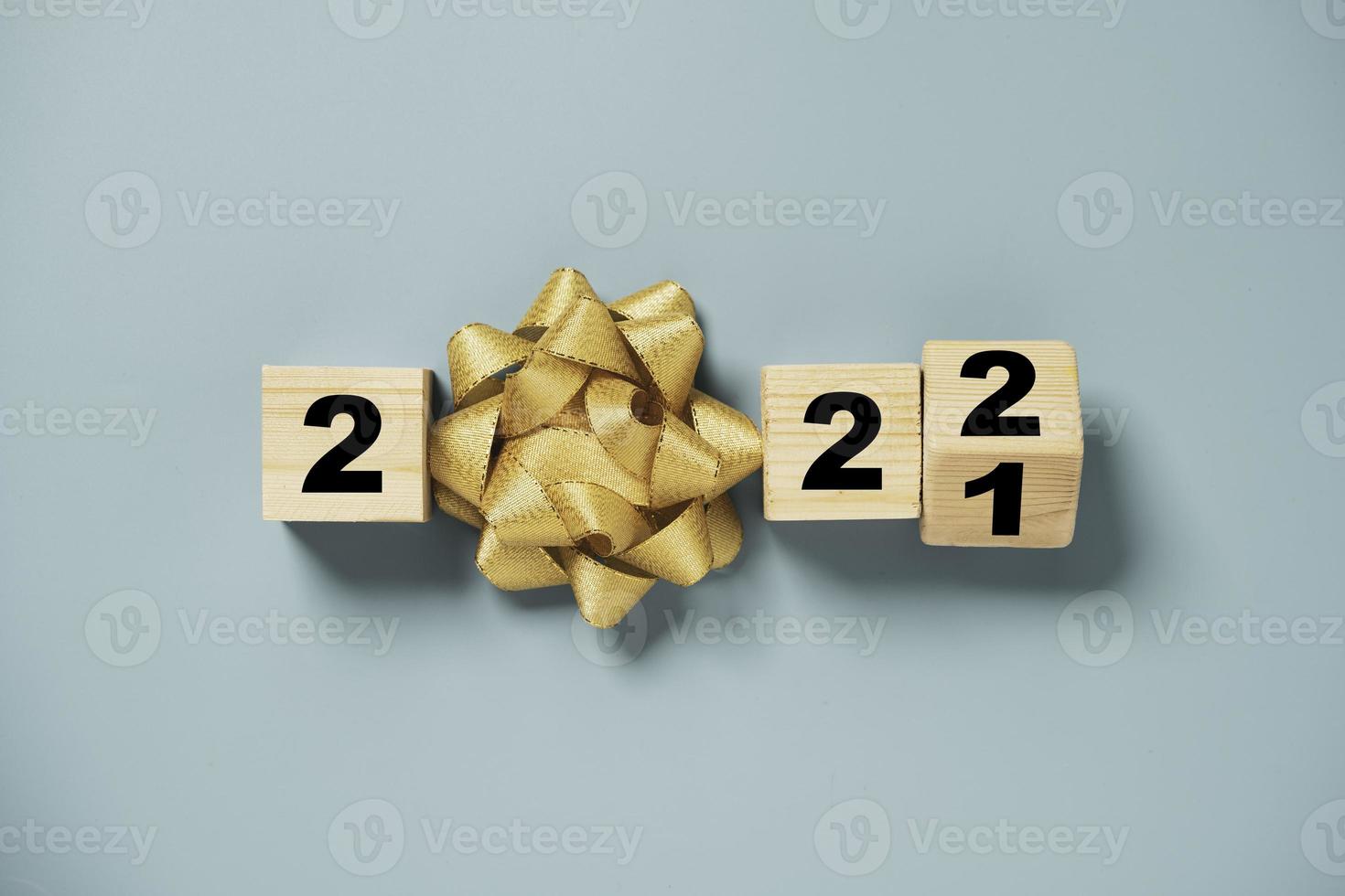 flipping houten kubusblok voor verandering 2021 tot 2022 met gouden strik voor voorbereiding vrolijk kerstfeest en gelukkig nieuwjaar concept. foto