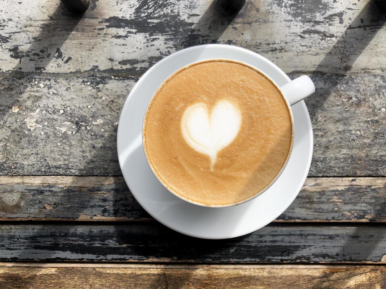 hart latte art op koffiekopje op houten tafel foto