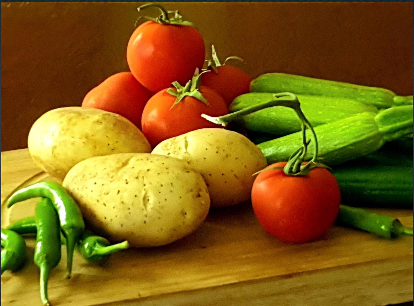 een groep verse groenten bestaande uit aardappelen, tomaten, courgette en groene pepers foto
