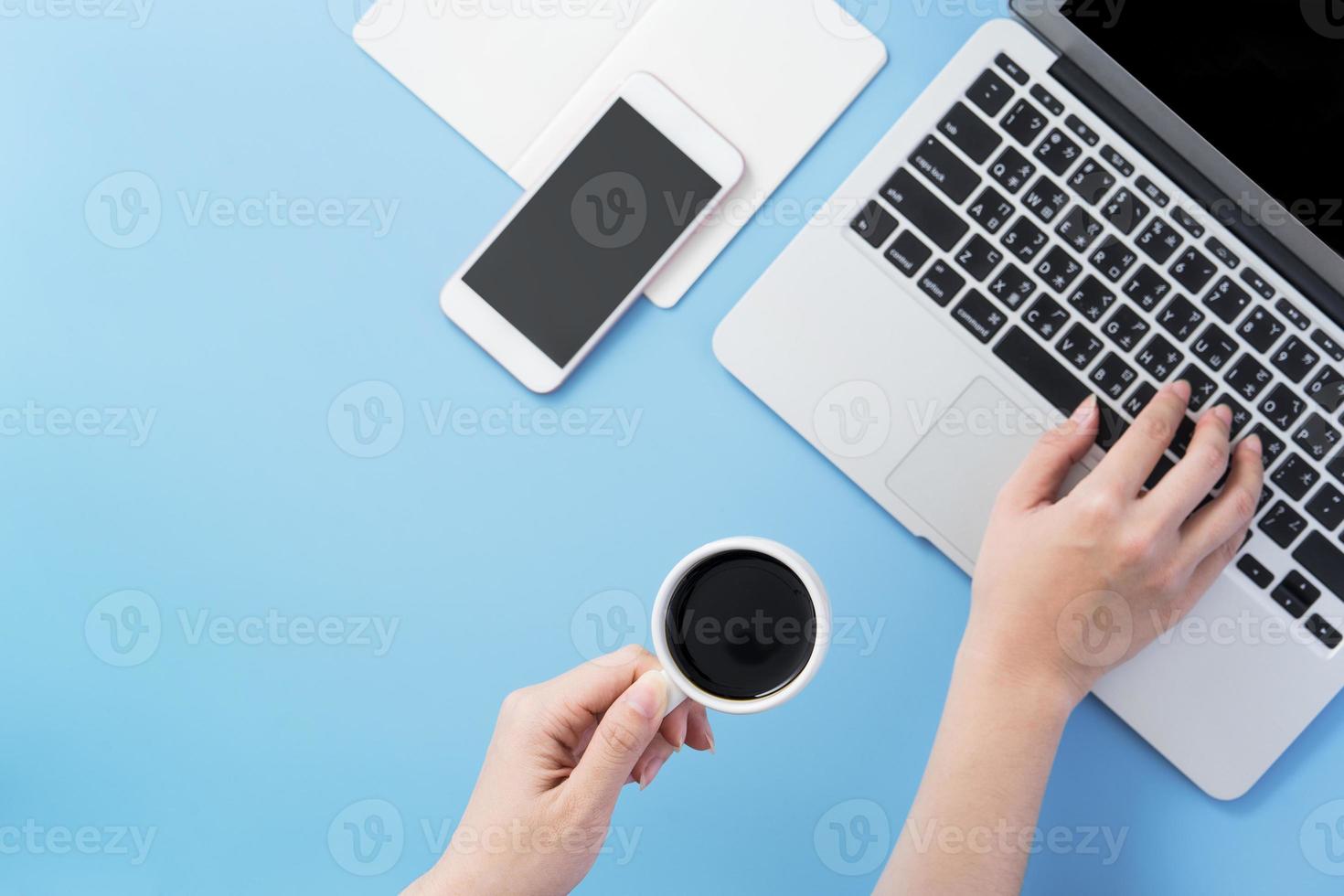vrouw surfen op internet voor het zoeken naar werk. freelancer blogschrijver typen op een cleam lichtblauw bureau met koffie, kopieerruimte, plat leggen, bovenaanzicht, mock-up foto