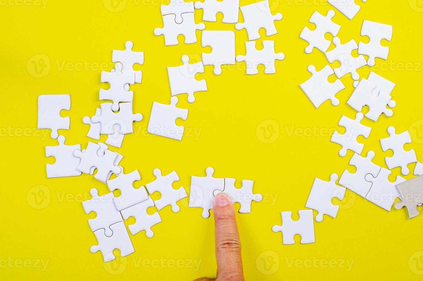 puzzel en handen op de gele conceptenachtergrond foto