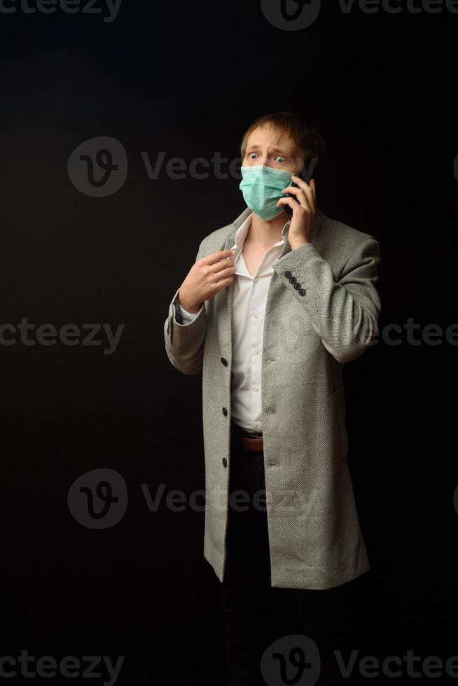 een man in een jas praat aan de telefoon met zijn arts. foto