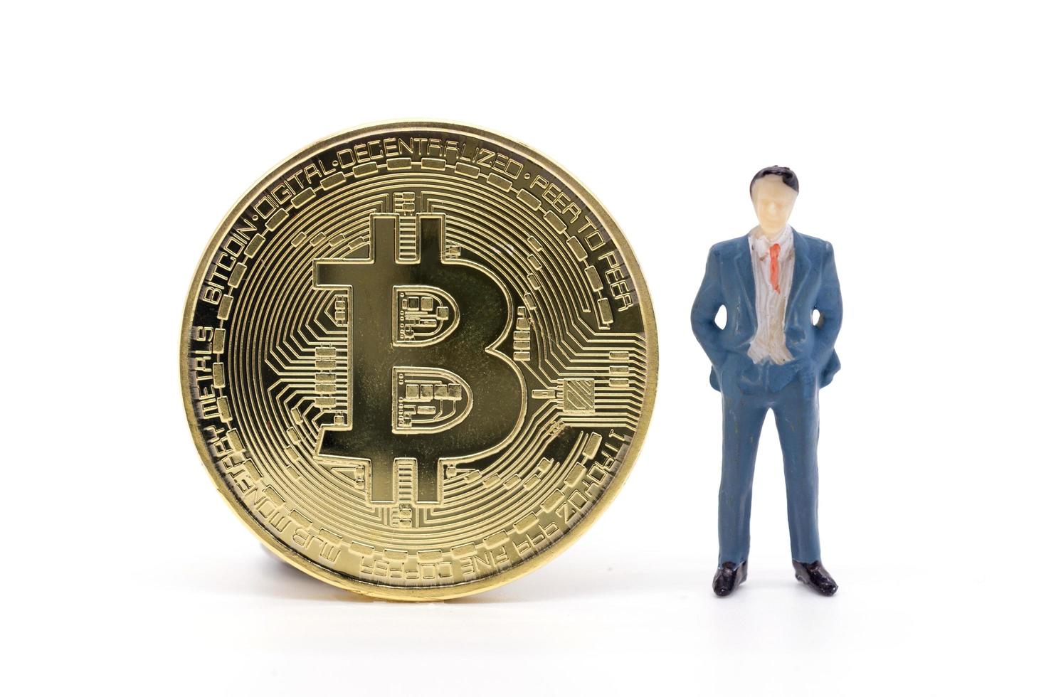 miniatuur zakenman en bitcoin op witte achtergrond foto